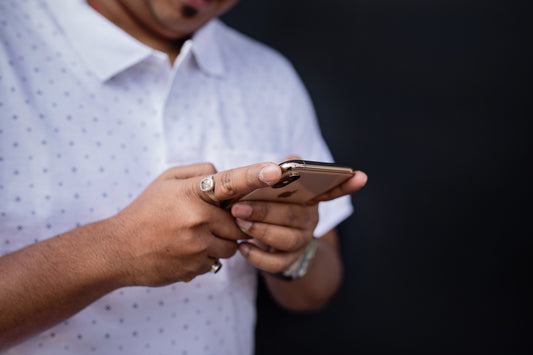 Hands holding a phone presumably a new EV owner browsing through charging glossary of terms